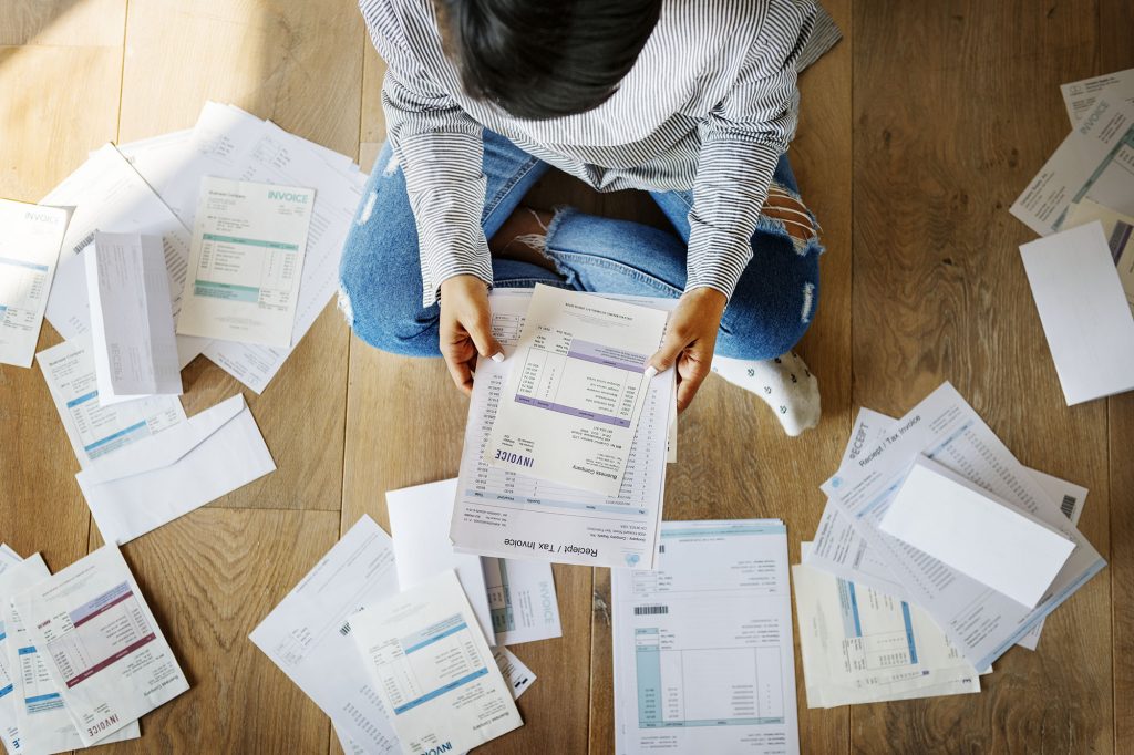 A woman sits holding her debt notes